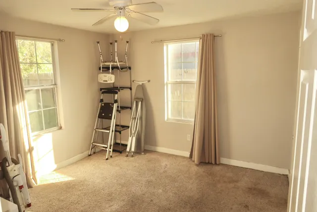 a view of a room with a window and furniture