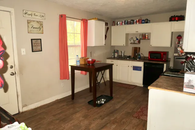 a kitchen with granite countertop a sink cabinets and appliances