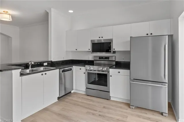 a kitchen with a refrigerator stove and white cabinets