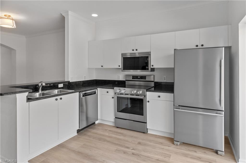 3281 Lindsey Lane, Unit 55 Naples, FL 34109 - Photo 1 of 43 a kitchen with a refrigerator stove and white cabinets
