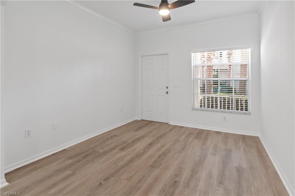 3281 Lindsey Lane, Unit 55 Naples, FL 34109 - Photo 11 of 43 an empty room with wooden floor fan and windows