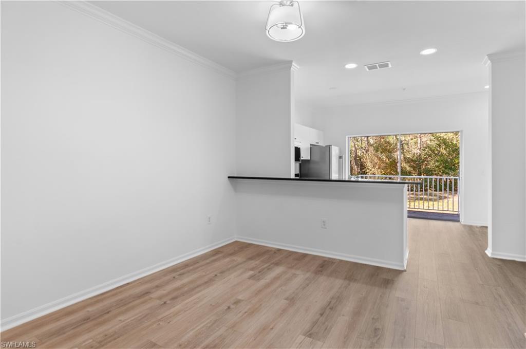 3281 Lindsey Lane, Unit 55 Naples, FL 34109 - Photo 12 of 43 an empty room with wooden floor and windows