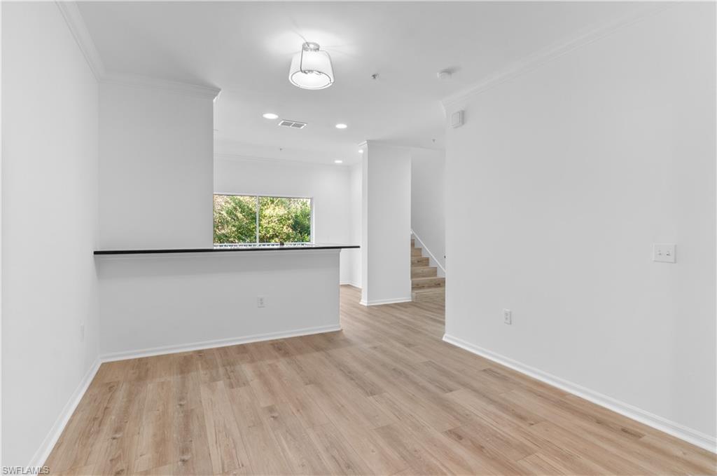 3281 Lindsey Lane, Unit 55 Naples, FL 34109 - Photo 13 of 43 wooden floor in an empty room with a window