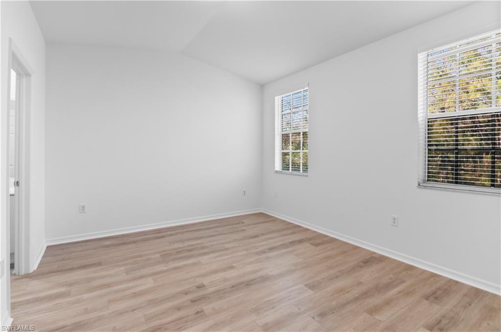 3281 Lindsey Lane, Unit 55 Naples, FL 34109 - Photo 15 of 43 wooden floor in an empty room with a window
