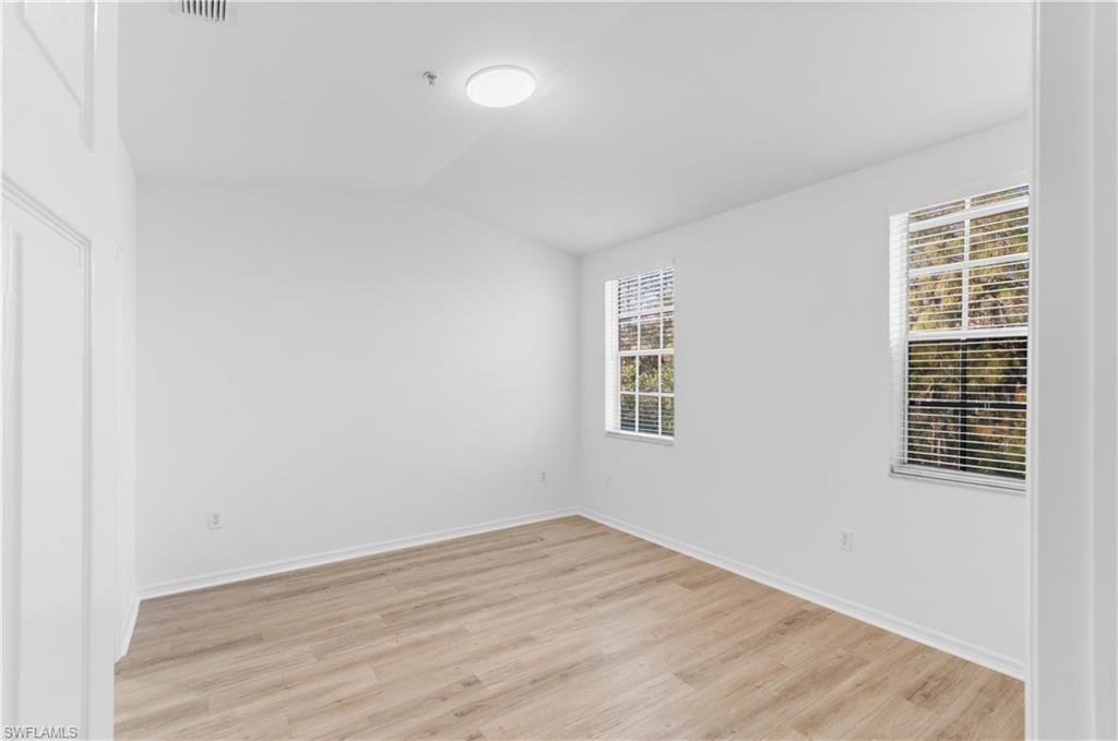 3281 Lindsey Lane, Unit 55 Naples, FL 34109 - Photo 19 of 43 wooden floor in an empty room with a window