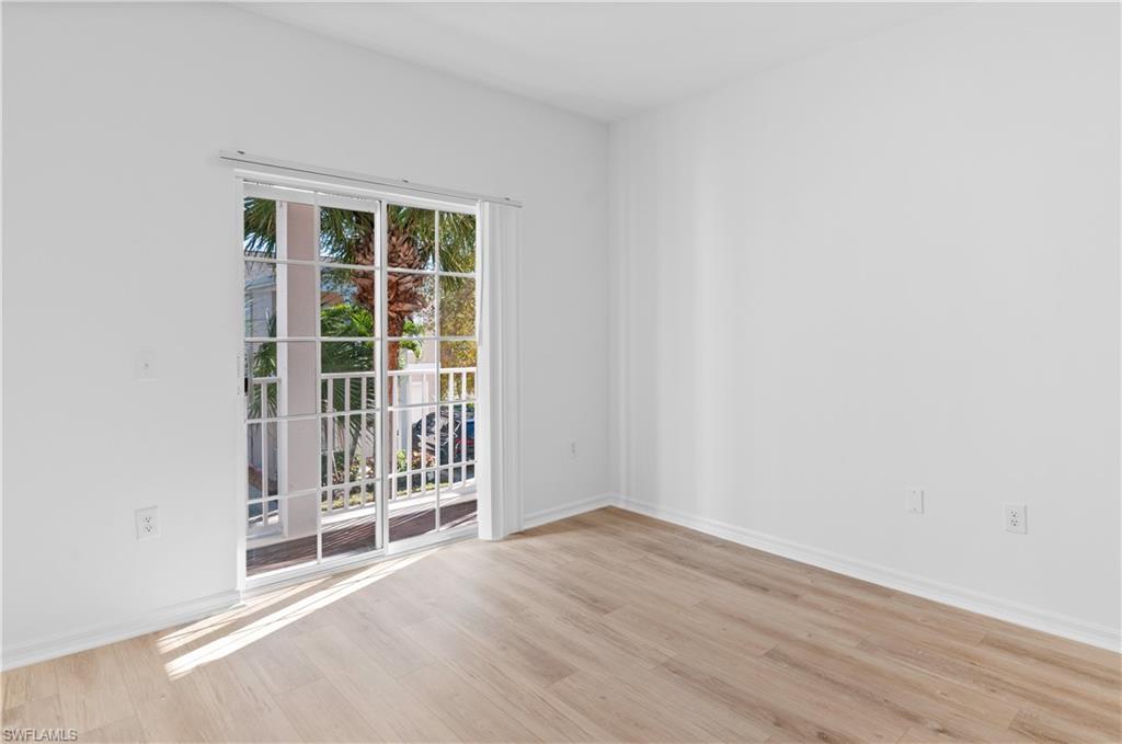3281 Lindsey Lane, Unit 55 Naples, FL 34109 - Photo 20 of 43 an empty room with wooden floor and windows