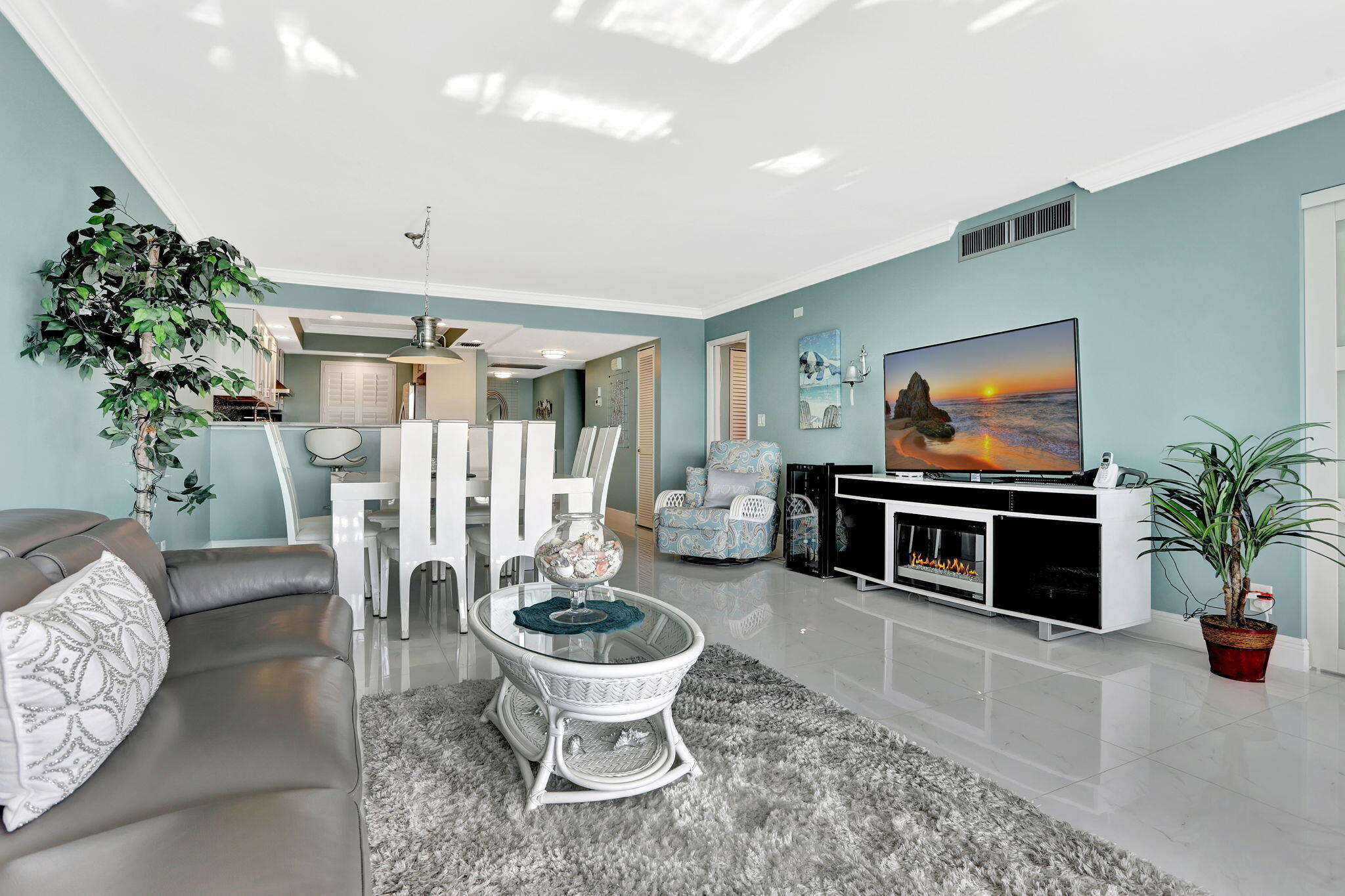 565 Oaks Lane, Unit 512 Pompano Beach, FL 33069 - Photo 15 of 34 a living room with furniture a flat screen tv and a potted plant