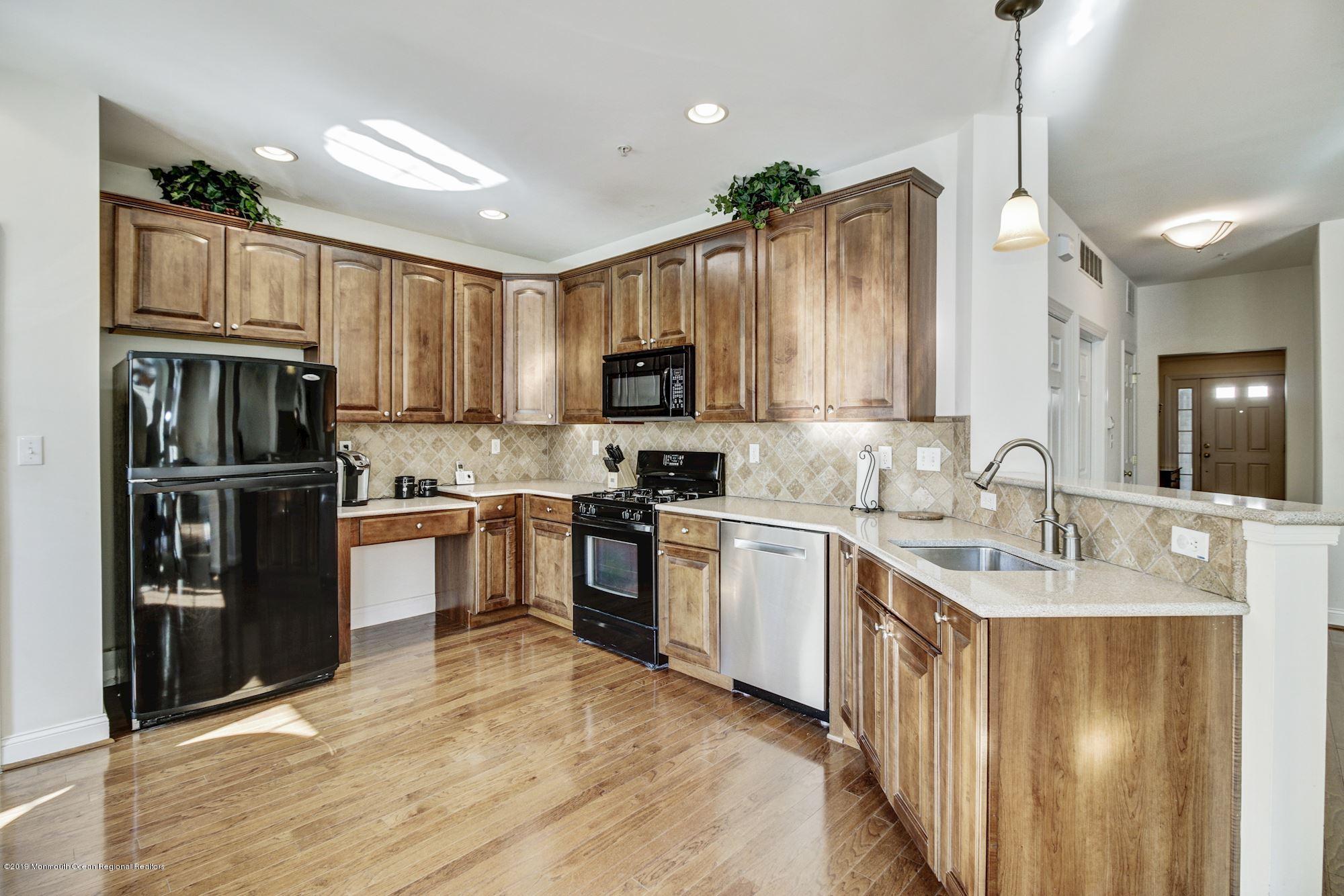 1006 Abby Road Middletown, NJ 07748 - Photo 17 of 44 a kitchen with kitchen island granite countertop a stove top oven a sink and a refrigerator