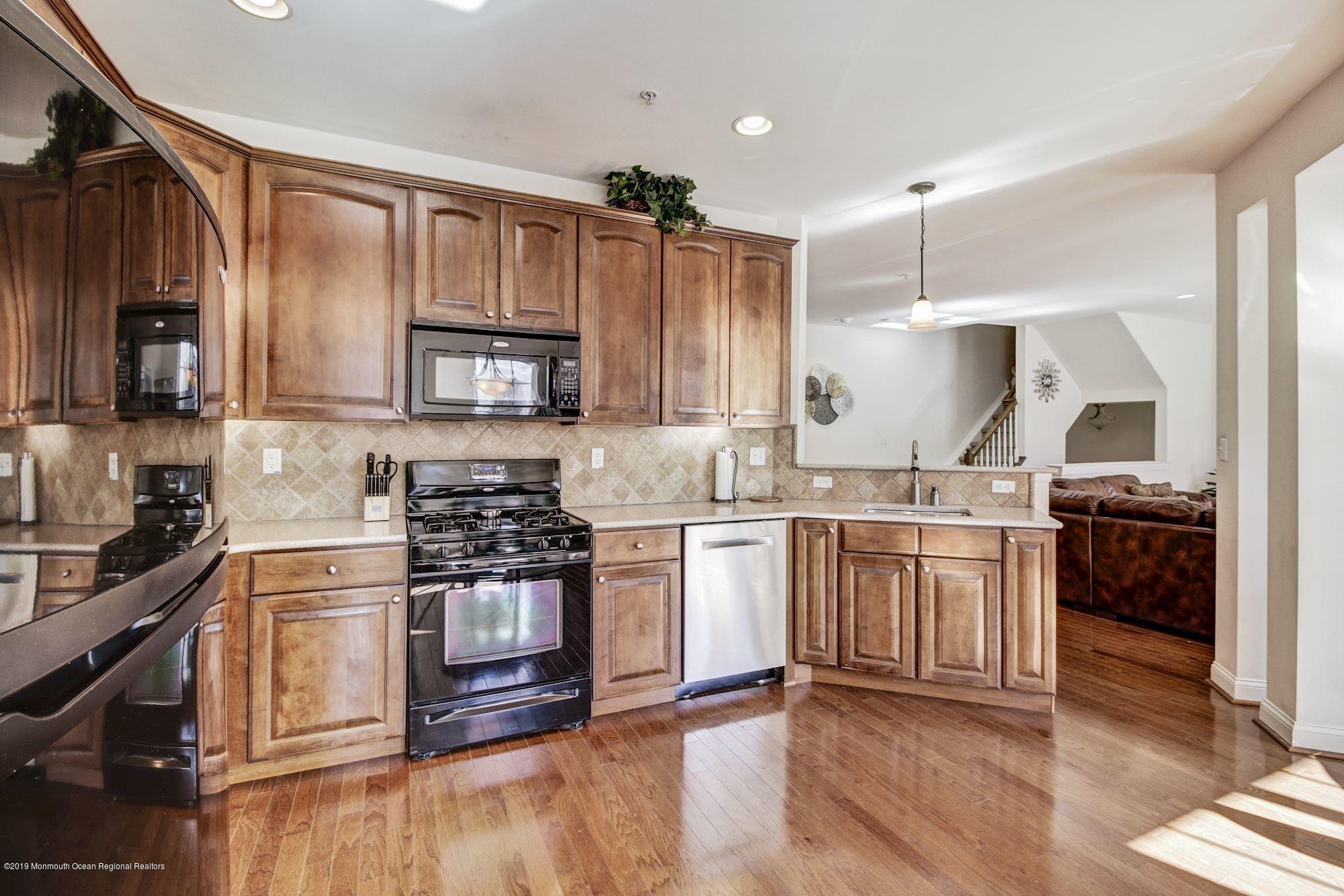 1006 Abby Road Middletown, NJ 07748 - Photo 18 of 44 a kitchen with stainless steel appliances granite countertop a stove top oven a sink and a refrigerator