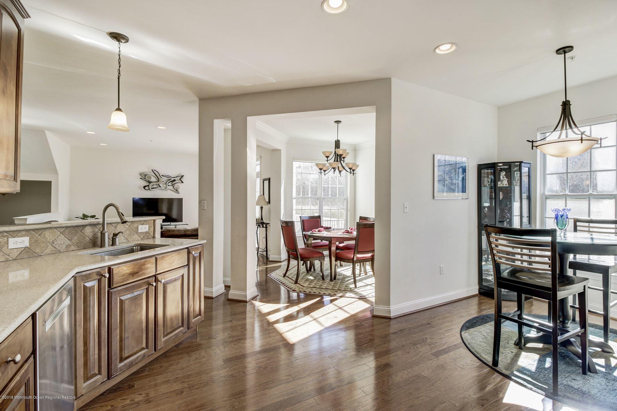 1006 Abby Road Middletown, NJ 07748 - Photo 22 of 44 a open kitchen with stainless steel appliances granite countertop a stove top oven a sink a dining table and chairs with wooden floor