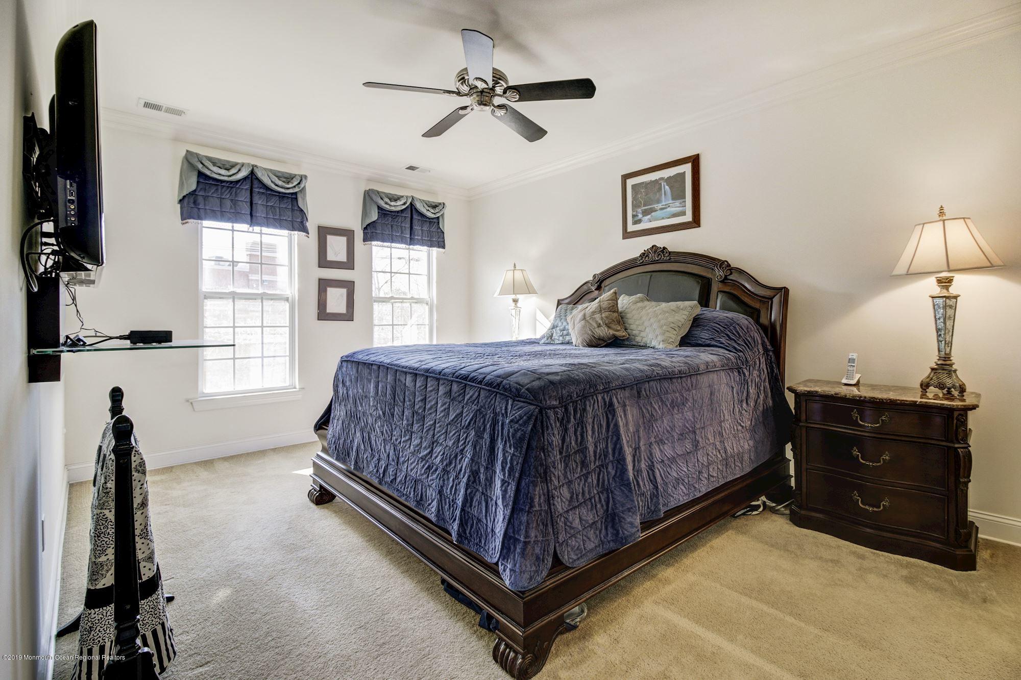 1006 Abby Road Middletown, NJ 07748 - Photo 23 of 44 a bedroom with a bed and a chandelier