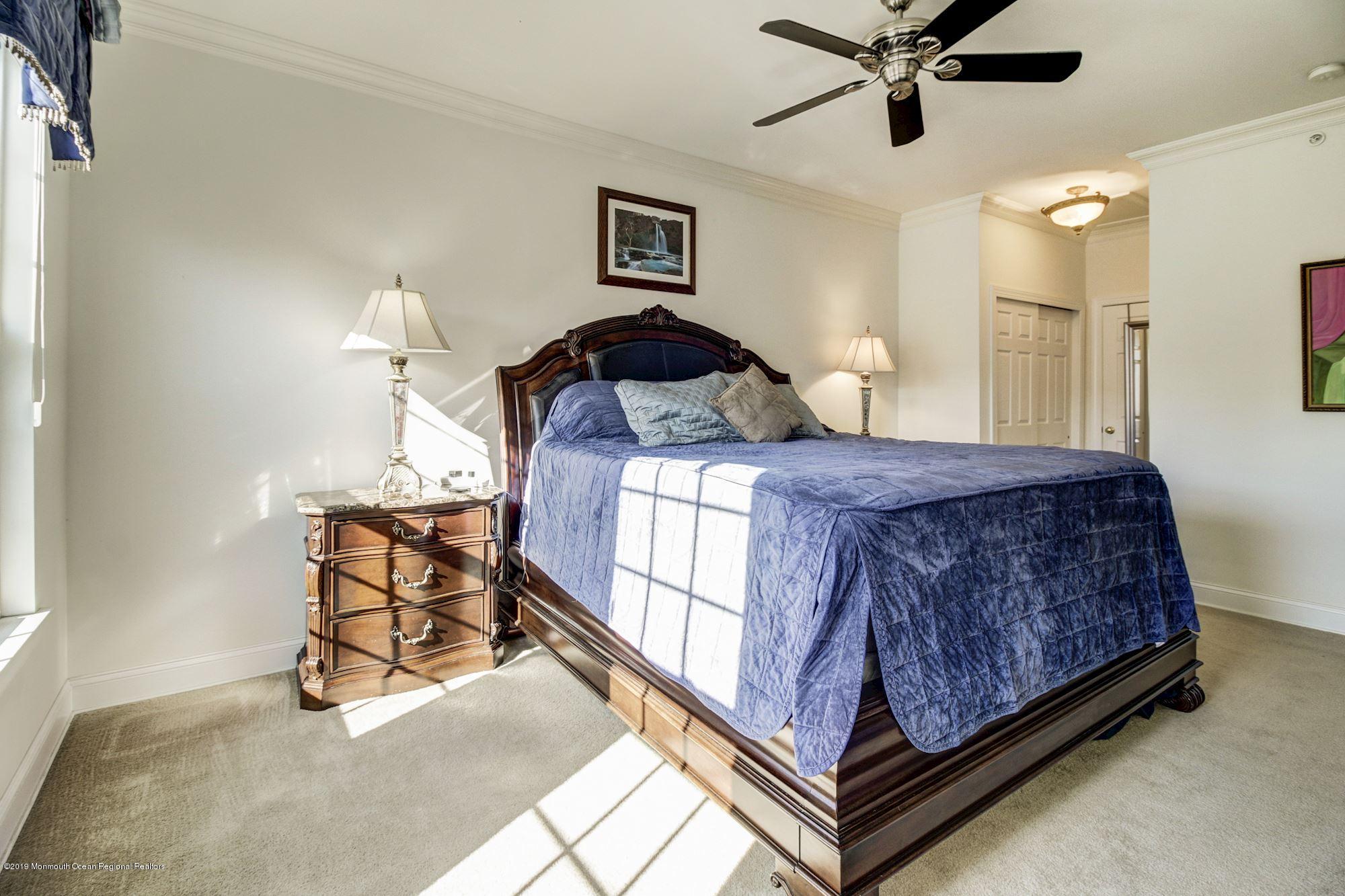 1006 Abby Road Middletown, NJ 07748 - Photo 25 of 44 a bedroom with a bed and a chandelier