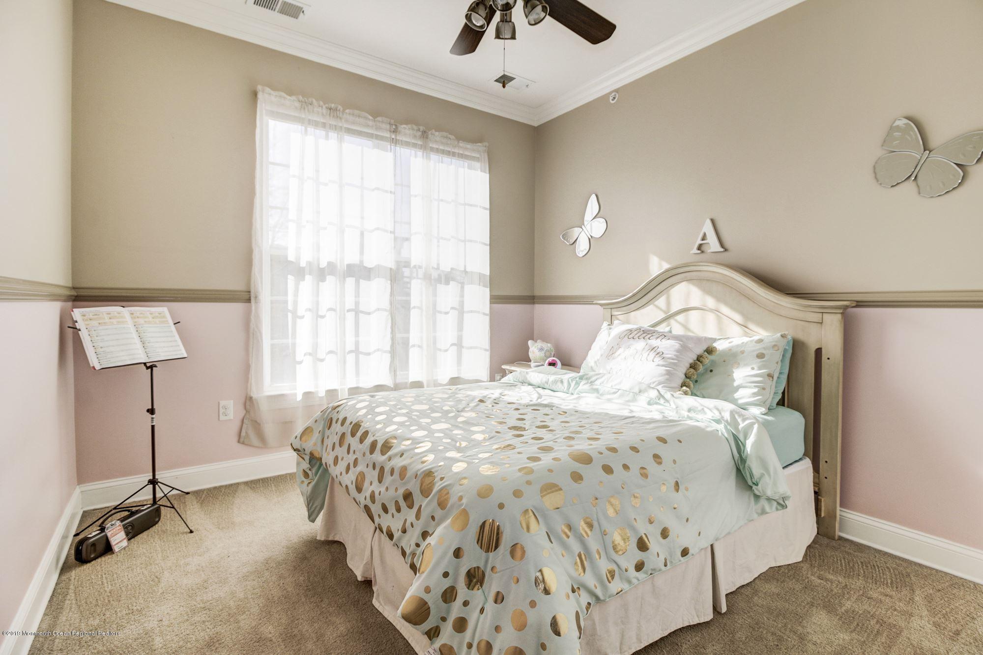 1006 Abby Road Middletown, NJ 07748 - Photo 28 of 44 a bedroom with a bed and a chandelier