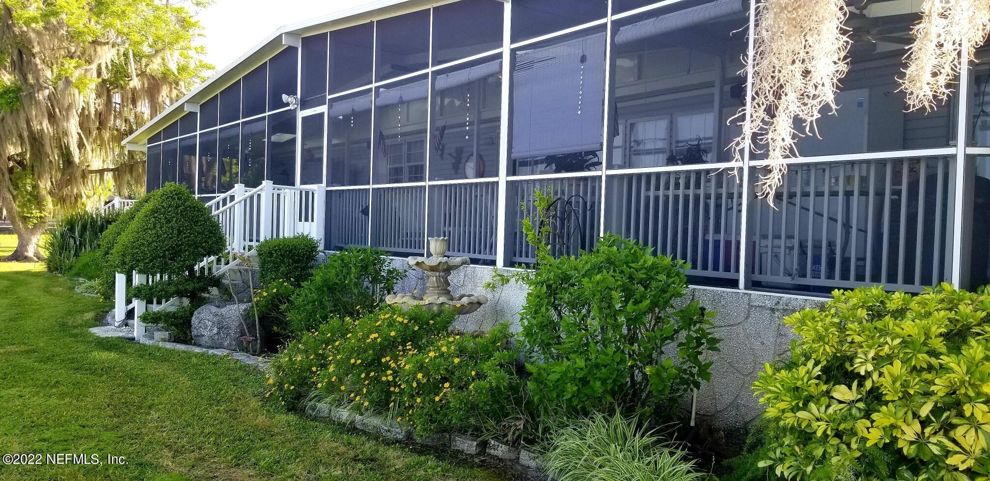 121 Jimmie Road Crescent City, FL 32112 - Photo 6 of 45 a view of a backyard with potted plants and floor to ceiling window and wooden fence