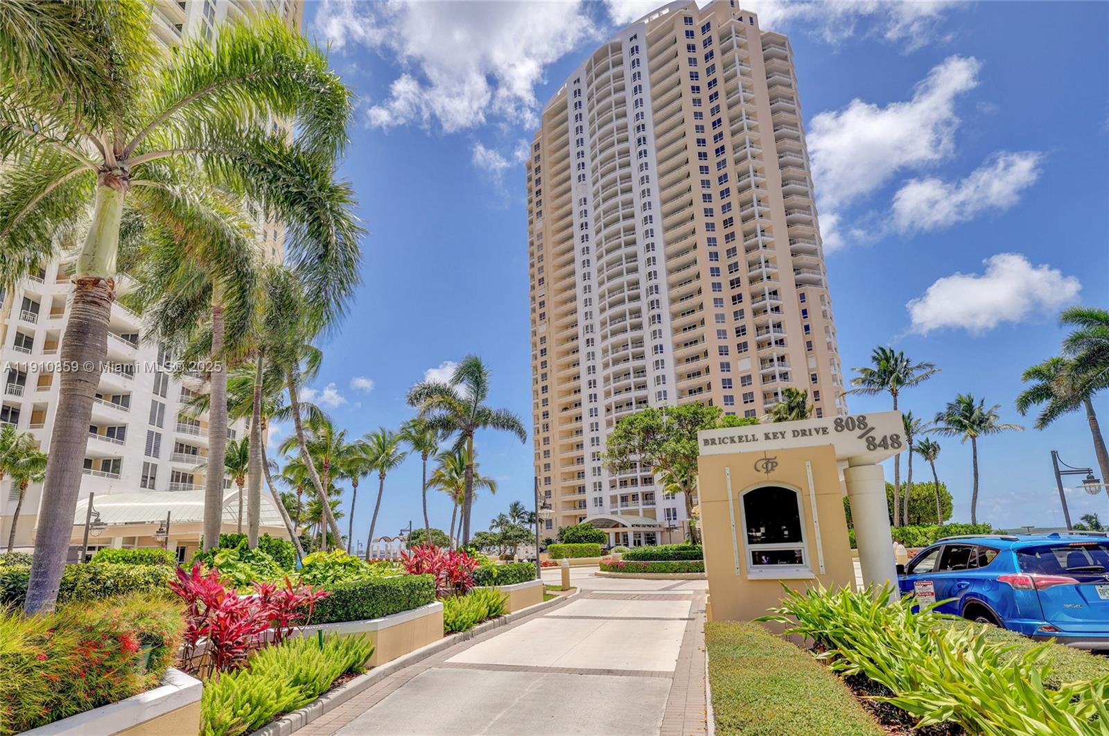 808 Brickell Key Drive, Unit 2104 Miami, FL 33131 - Photo 19 of 29 a front view of a multi story residential apartment building with yard and sign board