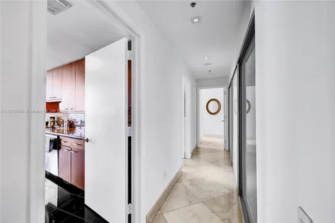a view of a hallway with closet and a bathroom