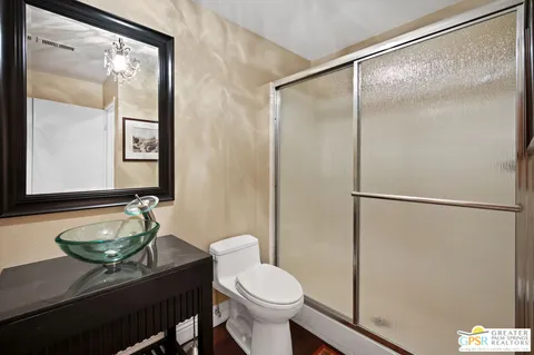 a bathroom with a granite countertop sink toilet and a mirror