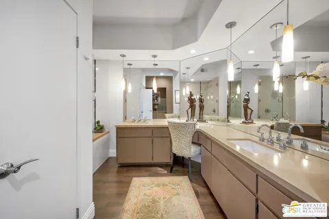 a large white bathroom with a large mirror vanity sink and a mirror