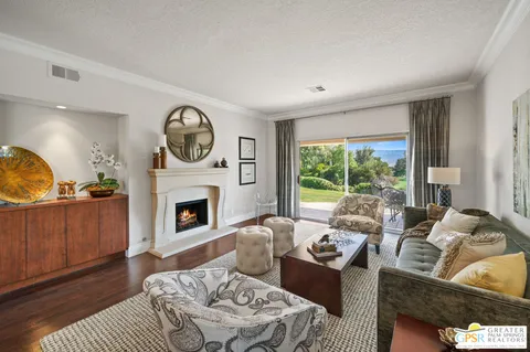 a living room with furniture a fireplace and a large window