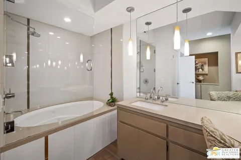 a bathroom with a bathtub shower sink double and mirror