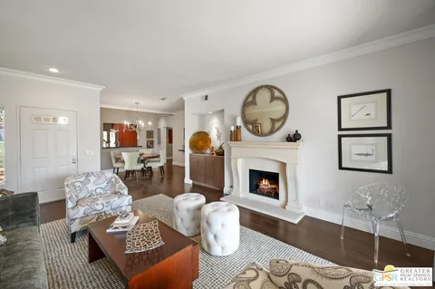 a living room with furniture a fireplace and wall paintings