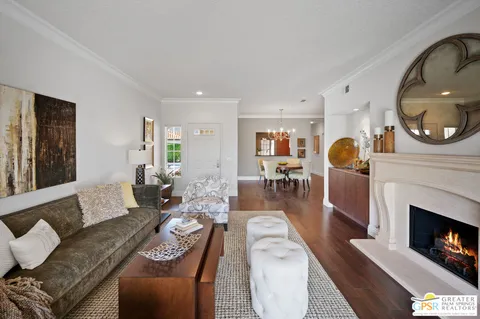 a living room with furniture a fireplace a rug and a window