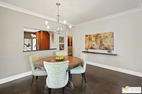 a dining room with furniture a chandelier and wooden floor