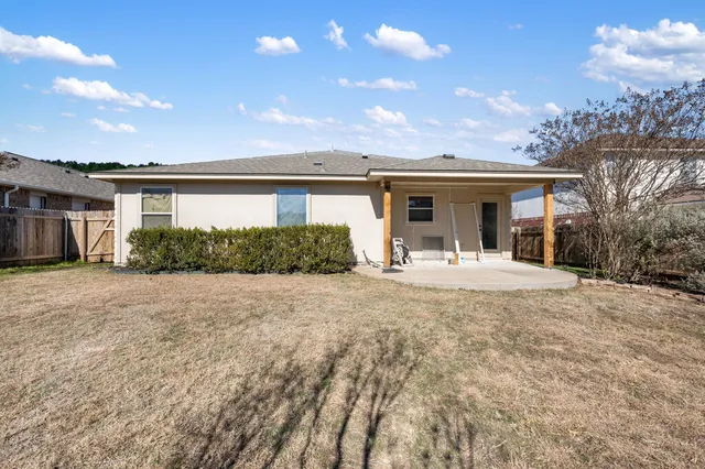 a view of a house with backyard and a tree