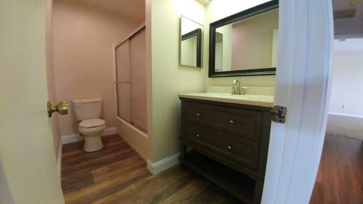 1841 Southwest Palm City Road, Unit D102 Stuart, FL 34994 - Photo 16 of 17 a bathroom with a sink a toilet and a mirror