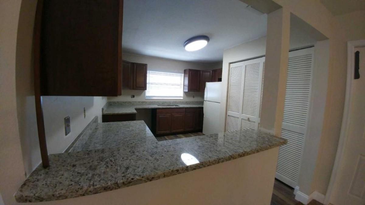 1841 Southwest Palm City Road, Unit D102 Stuart, FL 34994 - Photo 5 of 17 a kitchen with a sink and a refrigerator