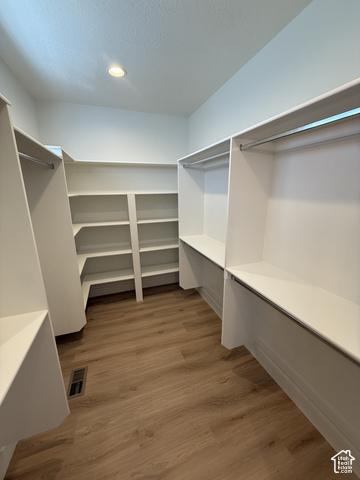 658 West 500 South, Unit 2 Logan, UT 84321 - Photo 11 of 18 Expansive walk-in closet featuring wood-finish flooring, recessed lighting, white built-in shelving, and hanging rods