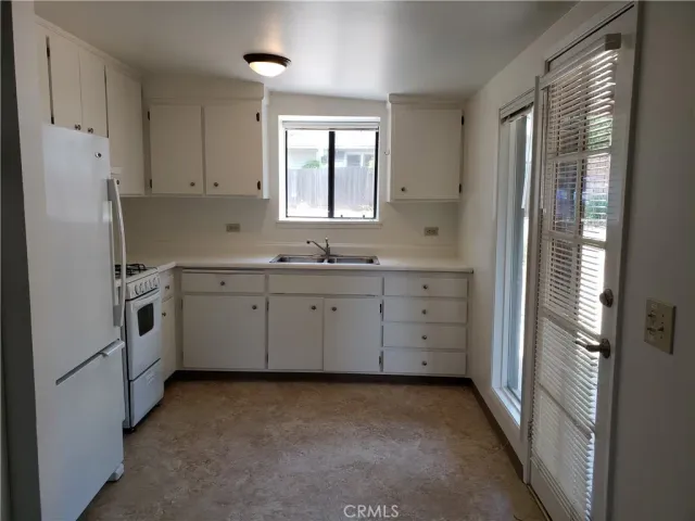 a kitchen with white cabinets and white appliances