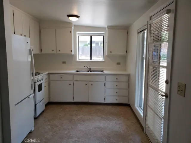 a kitchen with white cabinets and white appliances