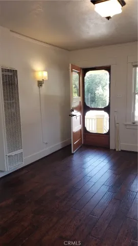a view of a hallway with bathroom and wooden floor