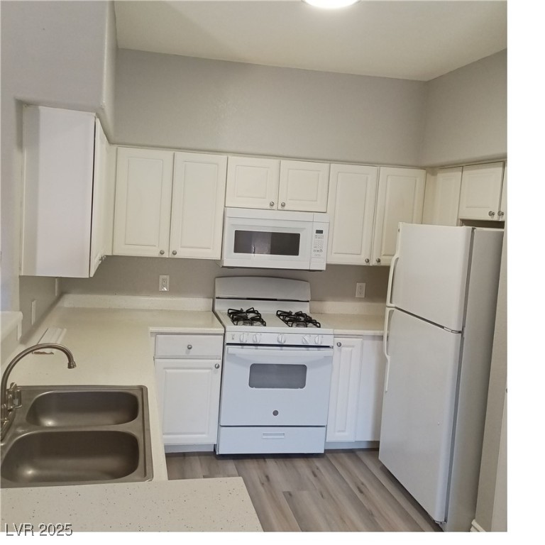 9000 South Las Vegas Boulevard, Unit 1239 Las Vegas, NV 89123 - Photo 2 of 10 Kitchen with white appliances, white cabinetry, light countertops, and light wood finished floors
