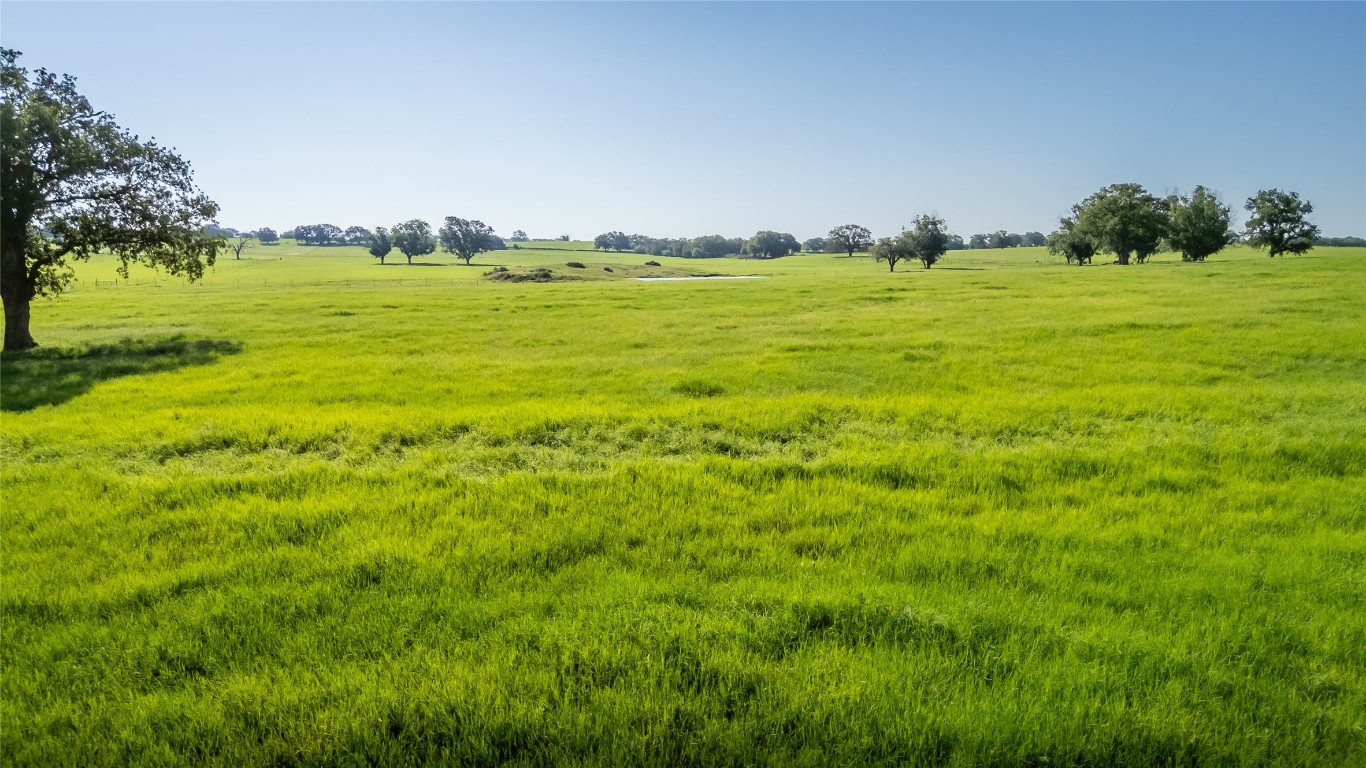 1483 County Road 255 Rochelle, TX 76872 - Photo 2 of 33 a view of a big yard with lots of green space and houses in the back