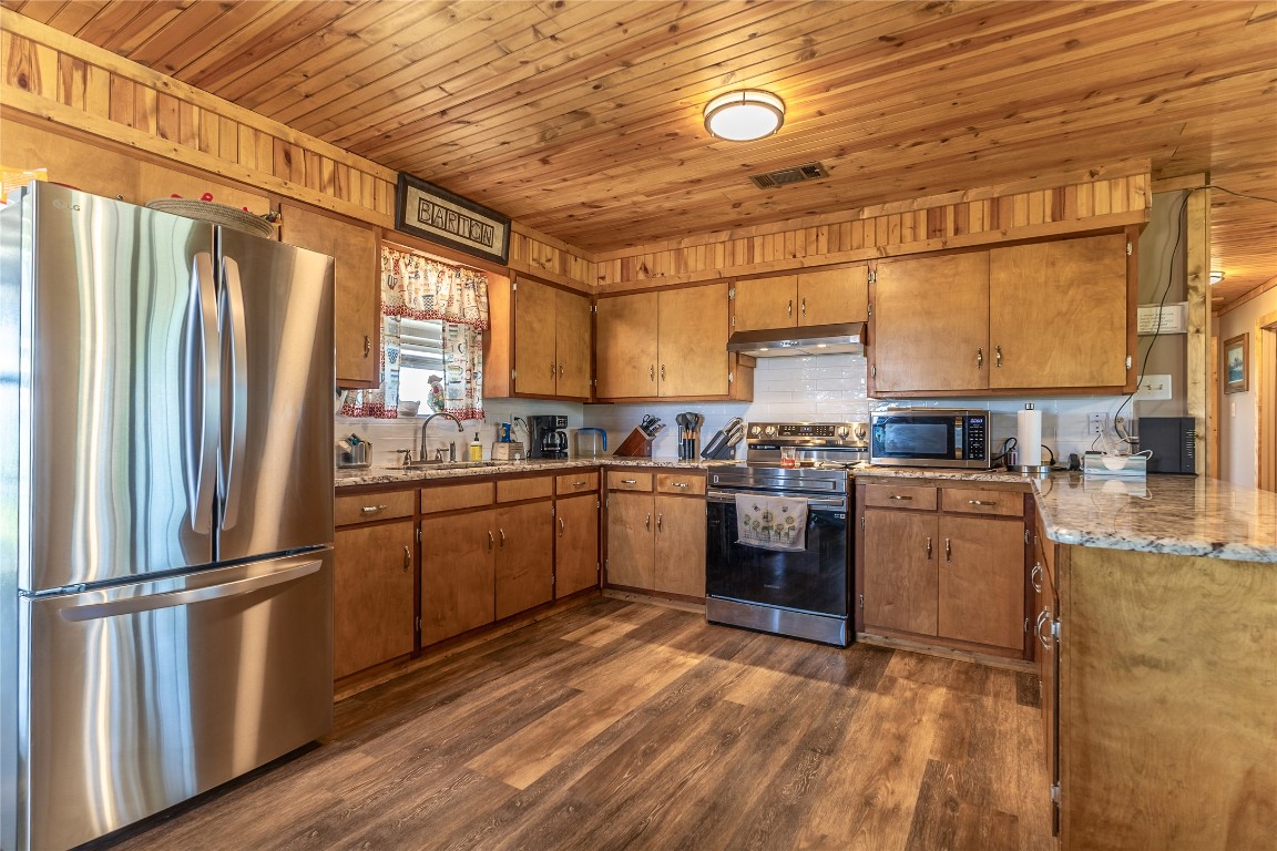 1483 County Road 255 Rochelle, TX 76872 - Photo 5 of 33 a kitchen with a refrigerator wooden floor a stove and a sink