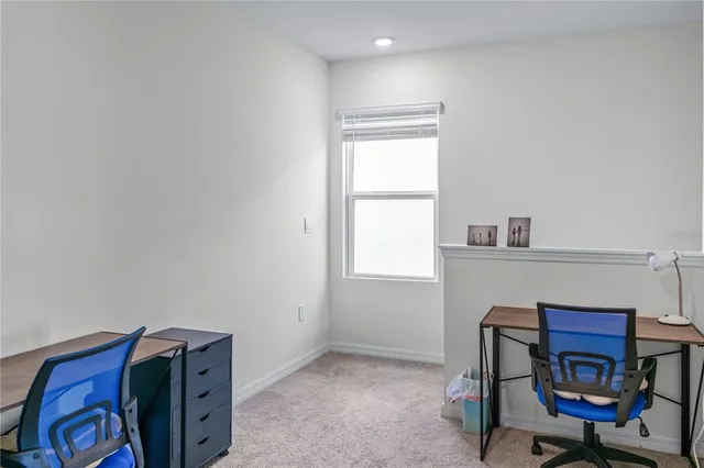 a view of a workspace with furniture and a window