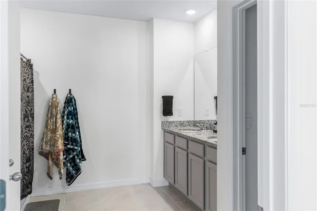 a bathroom with a granite countertop sink and a shower