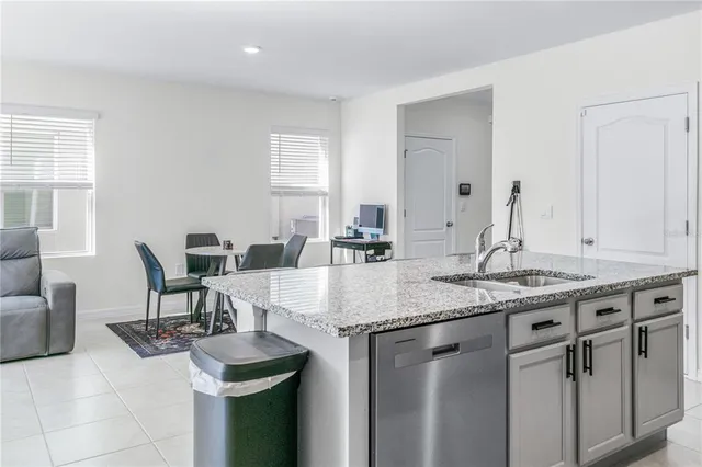 a kitchen with granite countertop a sink and a refrigerator