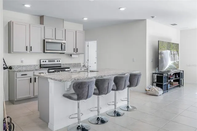 a kitchen with stainless steel appliances a stove a sink a microwave a refrigerator and cabinets