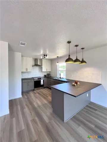 a kitchen with stainless steel appliances a sink stove and cabinets