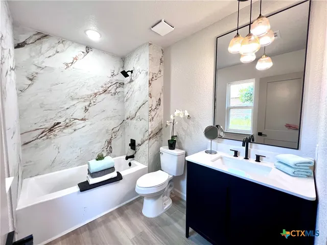 a bathroom with a double vanity sink toilet and shower