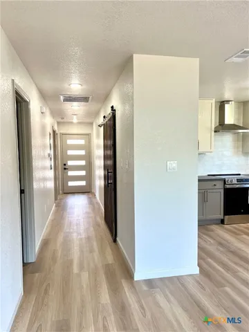 a view of a hallway with wooden floor