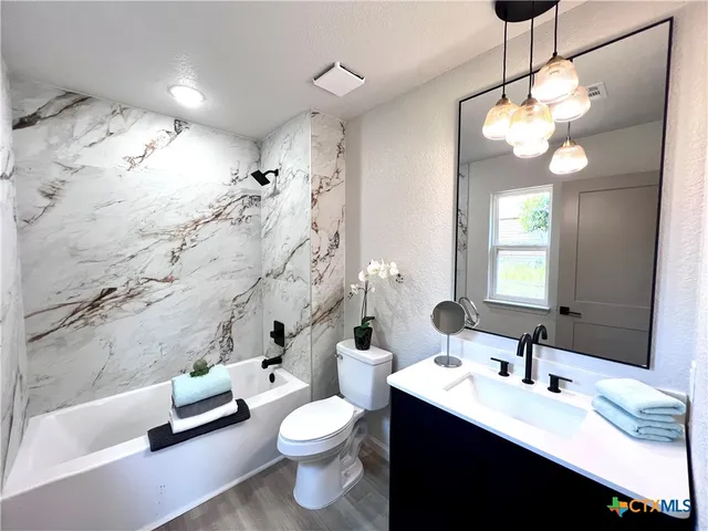a bathroom with a double vanity sink toilet and shower