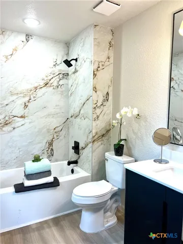 a bathroom with a sink a toilet and shower