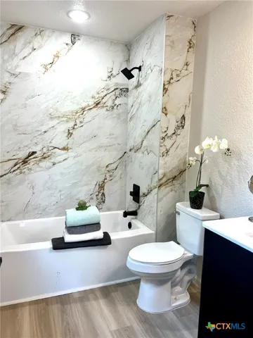 a white toilet sitting next to a bathroom sink and a shower