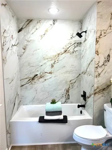 a bathroom with a white tub and shower