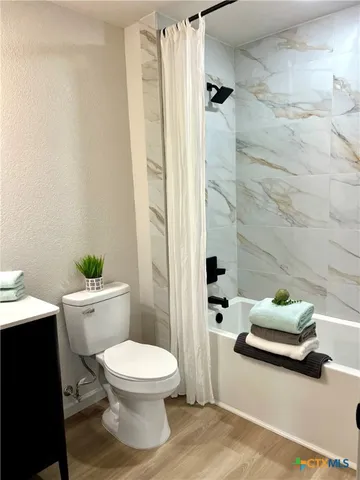 a bathroom with a toilet and a shower