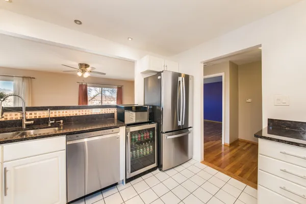 a kitchen with granite countertop a sink and a refrigerator